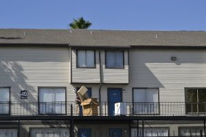 man carrying moving boxes into the house