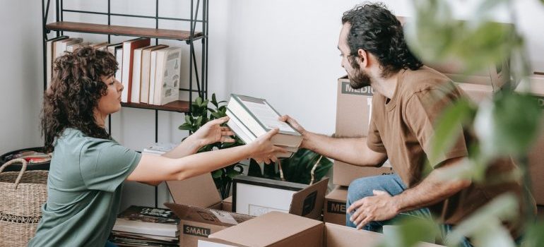 couple packing books into boxes