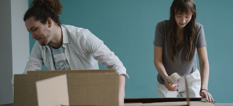 A couple packing boxes after learning about the benefits of using a Nomad-based storage facility