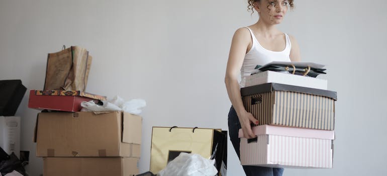 A woman carrying moving boxes 