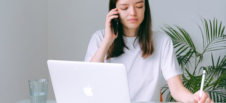 A woman on a call in front of her laptop