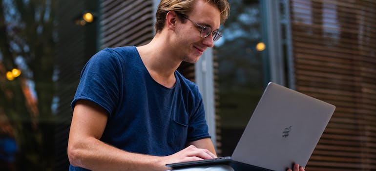 A man using a laptop to look up how to store electronics safely in a storage unit