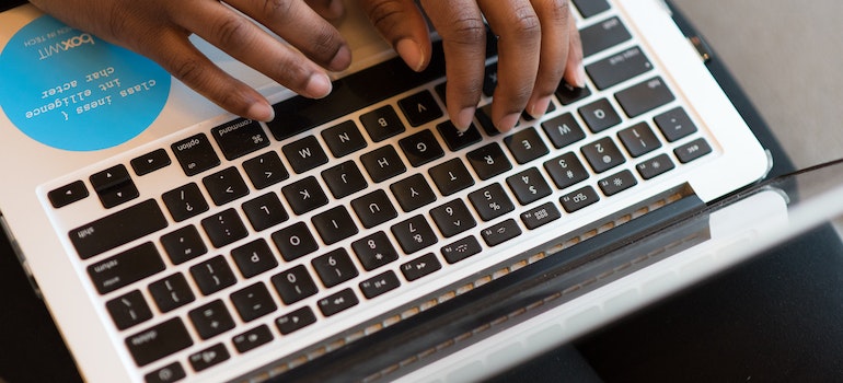 A person typing on a laptop keyboard