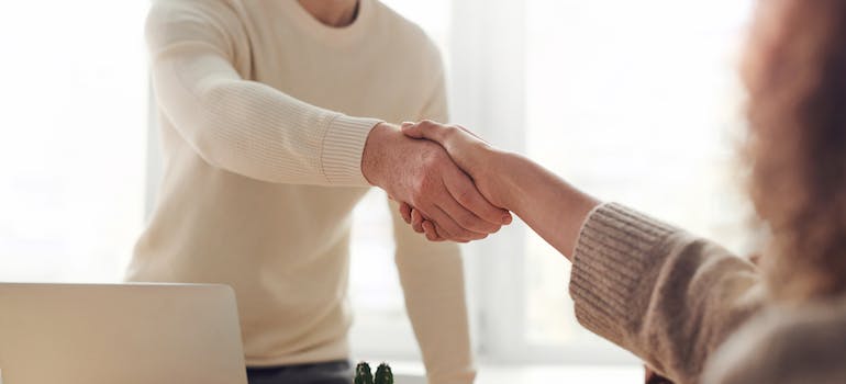 People shaking hands after a job interview in one of the top cities that Manhattan residents are moving to