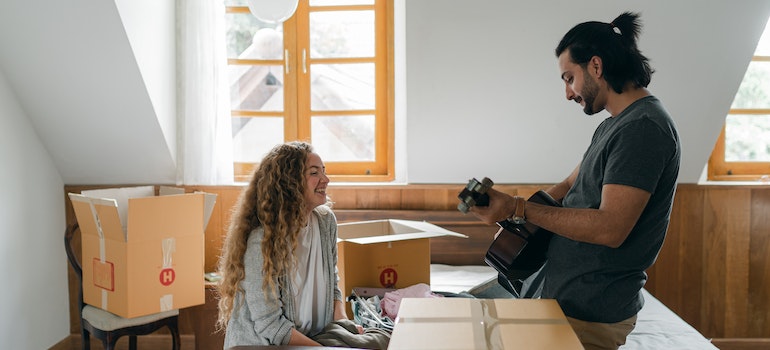 A couple joking around next to packing boxes