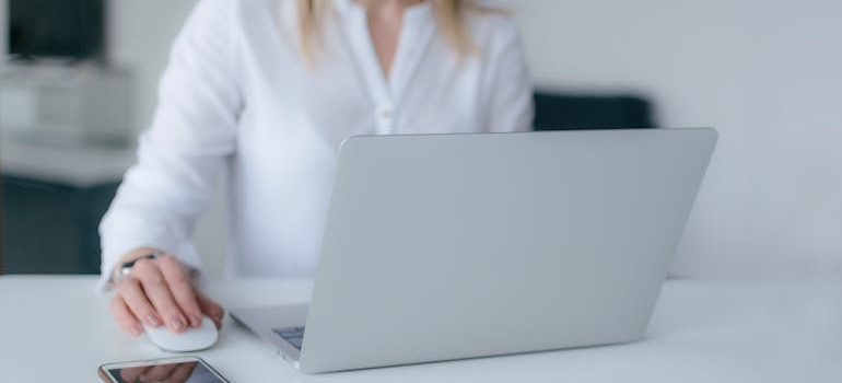 A person using their laptop to research the option of moving your startup location to Manhattan