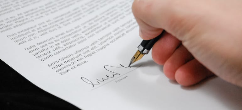 A person signing a document to store seasonal items in a storage unit