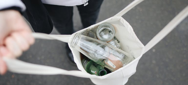 A person carrying their recycling in a tote bag