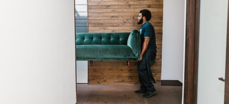 A professional mover carrying a couch when someone is moving from Union Square to the Financial District