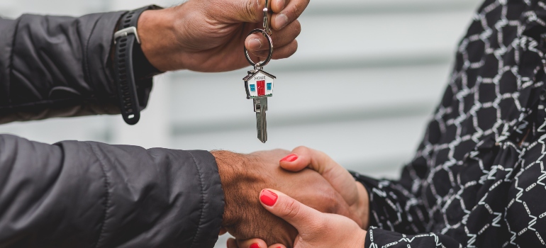 Person handing house keys