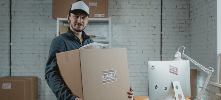 A Lincoln Square movers team member carrying items in a box