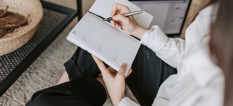 A person writing down a pet-friendly moving checklist in a planner