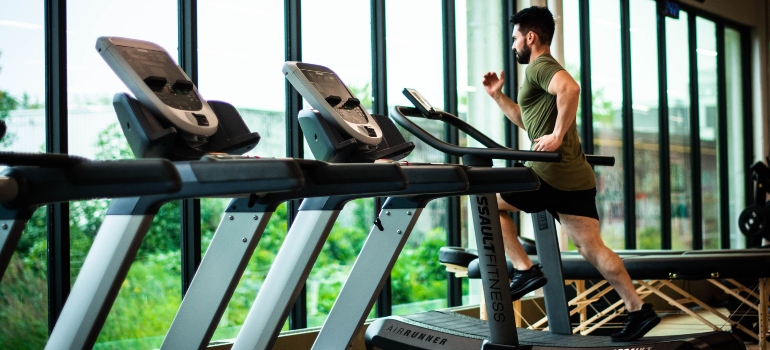 A man running on a treadmill after moving from Noho to the West Village