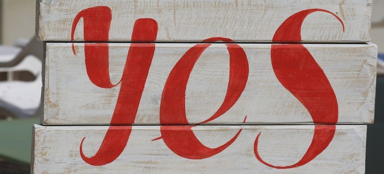 Red yes sign on a white wooden background